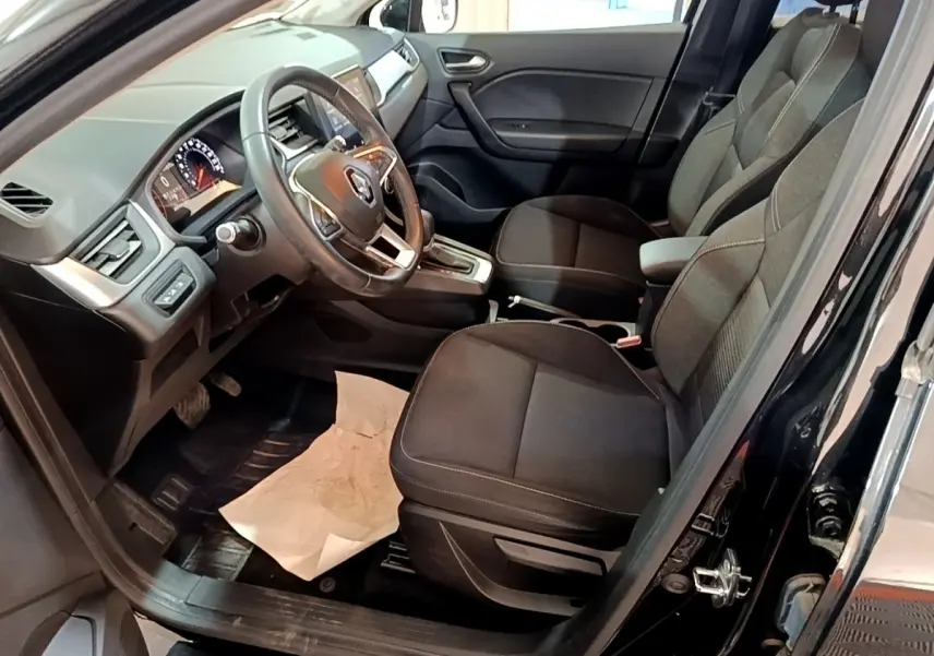 Vue intérieure côté conducteur du Renault Captur Business noir 2021, avec sièges tissu et volant multifonctions.