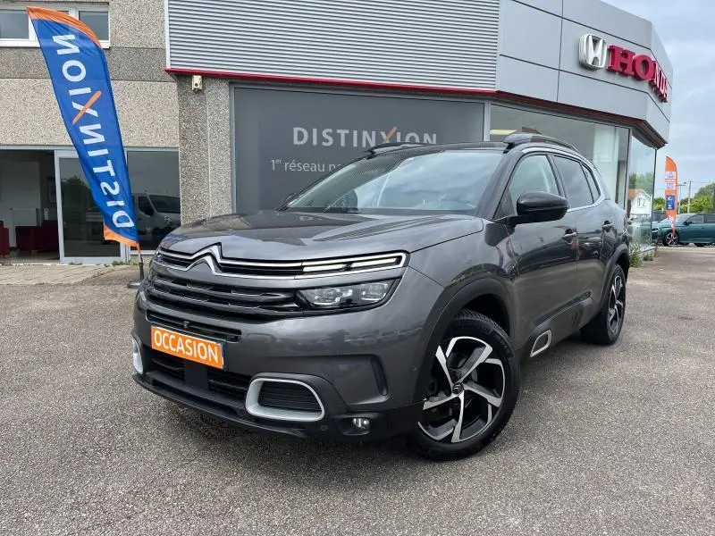 Citroën C5 Aircross gris acier vue 3/4 avant droit avec calandre noire et jantes alliage bicolores.