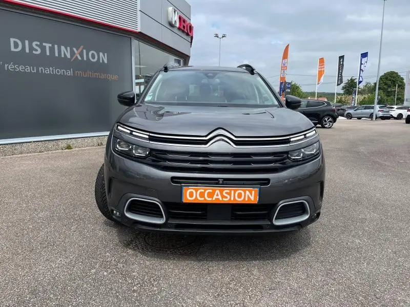 Vue frontale d'un Citroën C5 Aircross gris acier avec calandre distinctive et plaque "OCCASION" visible.