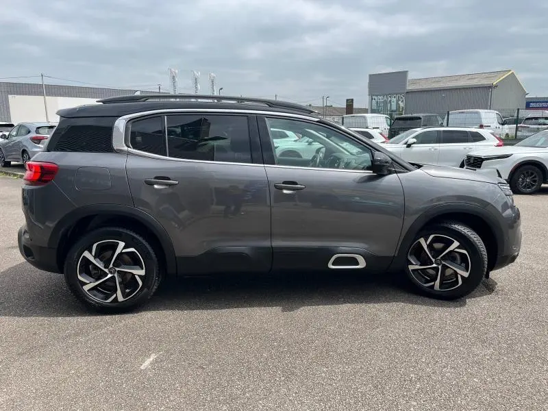 Vue latérale droite d'un Citroën C5 Aircross gris acier avec jantes alliage et vitres arrière surteintées.