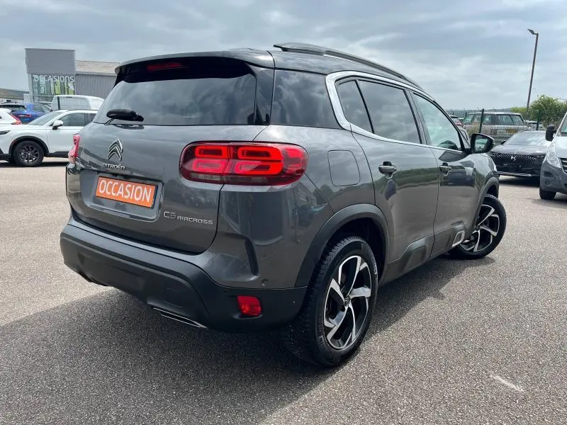 Vue 3/4 arrière droite d'un Citroën C5 Aircross gris acier avec feux arrière LED et jantes alliage bicolores.