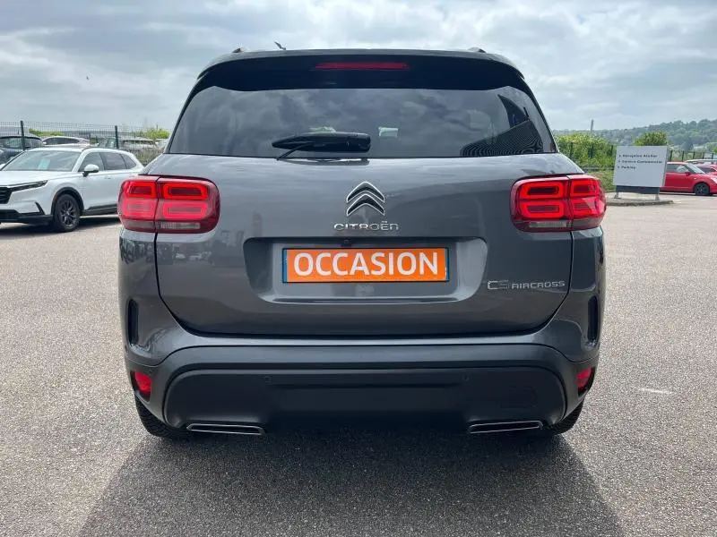 Vue arrière d'un Citroën C5 Aircross gris acier avec feux LED et double sortie d'échappement intégrée au pare-chocs noir.