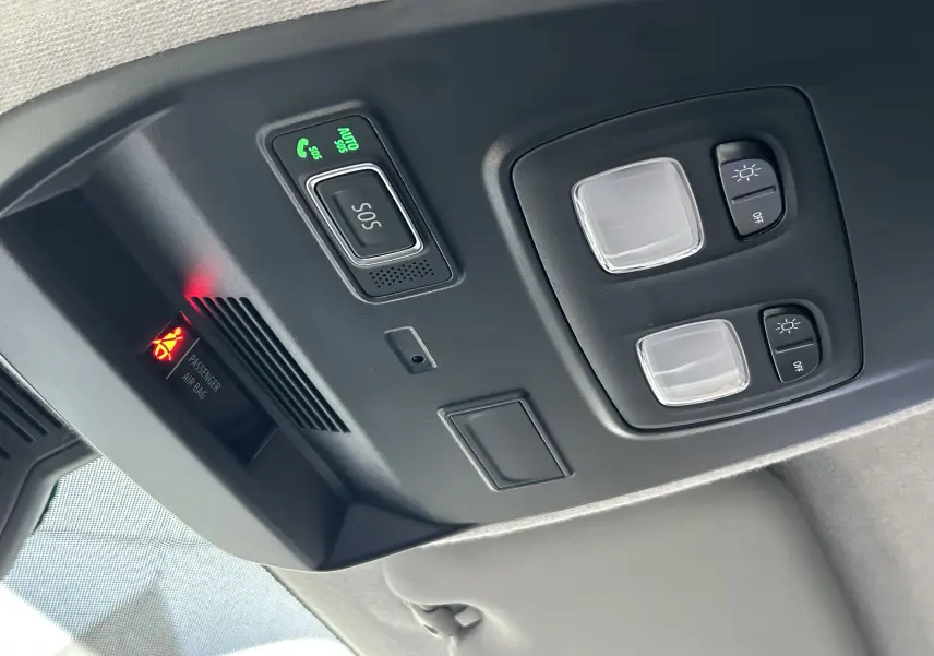 Vue en gros plan du plafonnier intérieur du Renault Trafic Fourgon 2025 avec boutons d'éclairage et alerte airbag passager.