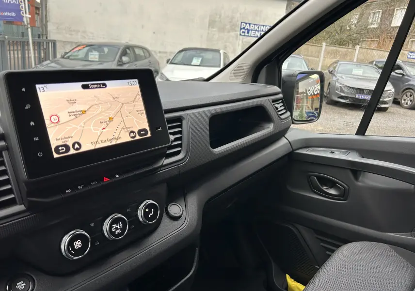 Vue intérieure côté passager du tableau de bord et écran tactile du Renault Trafic Fourgon gris Comète 2025.