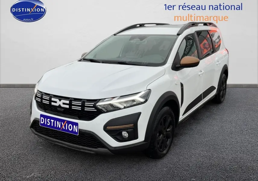 Vue 3/4 avant droite d'un Dacia Jogger blanc avec rétroviseurs marron et jantes noires sur fond neutre.