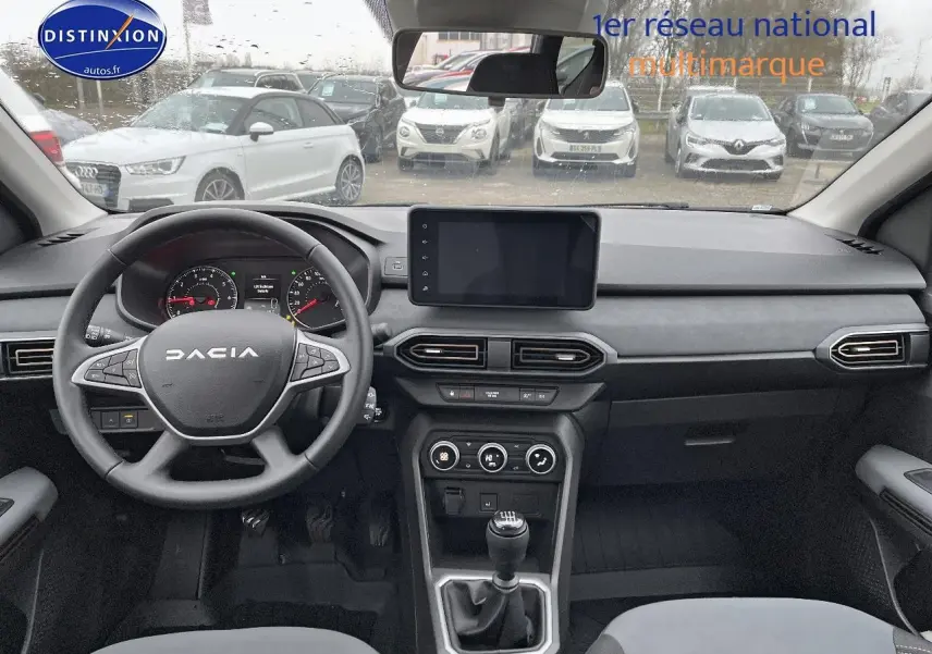 Vue intérieure frontale du tableau de bord et volant noir du Dacia Jogger 2025 avec écran tactile et boîte manuelle.