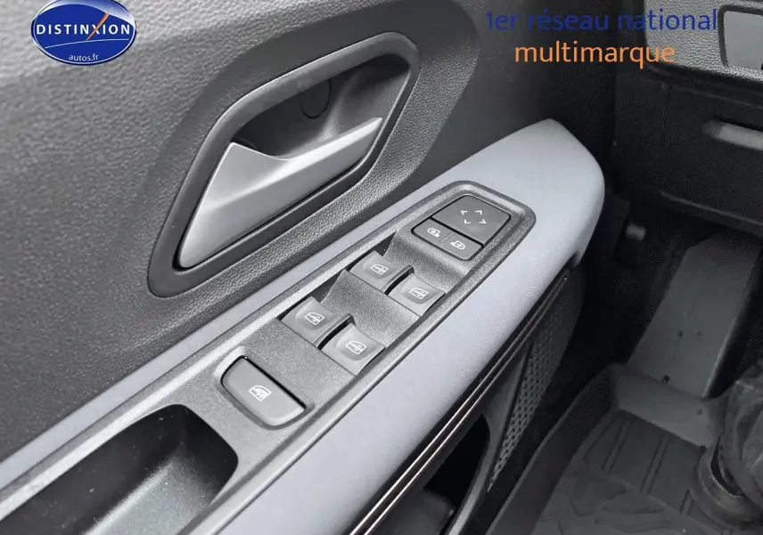 Gros plan sur la commande des vitres électriques côté conducteur du Dacia Jogger blanc, avec poignée de porte grise.