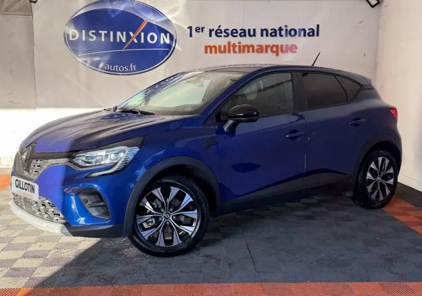 Renault Captur bleu 2024 en vue 3/4 avant droit, avec jantes alliage et phares LED visibles en intérieur showroom.