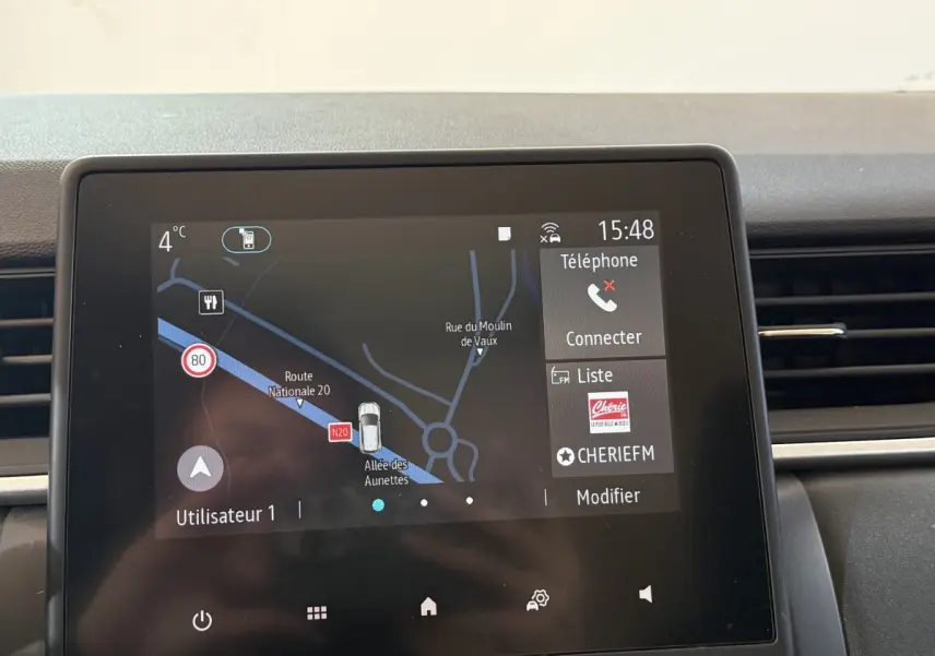 Écran tactile central du tableau de bord du Renault Captur bleu, affichant la navigation et les options multimédia.
