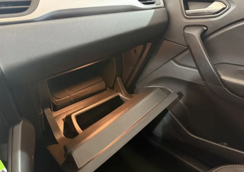 Vue intérieure côté passager du coffre à gants ouvert dans un Renault Captur bleu, version hybride 2024.