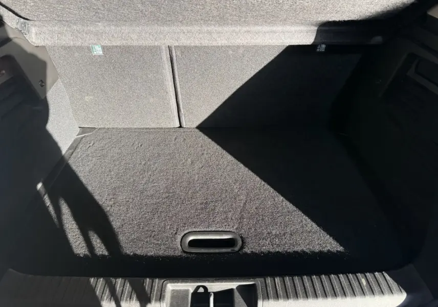 Coffre spacieux et propre du Renault Captur bleu, vue intérieure depuis l'arrière avec banquette rabattue.