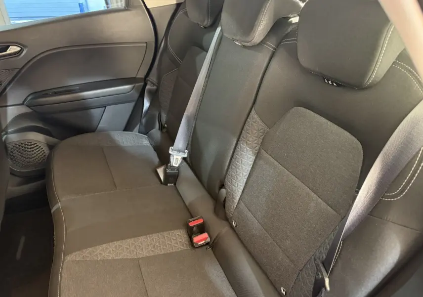 Vue intérieure côté droit montrant la banquette arrière noire du Renault Captur 2024 avec ceintures de sécurité visibles.