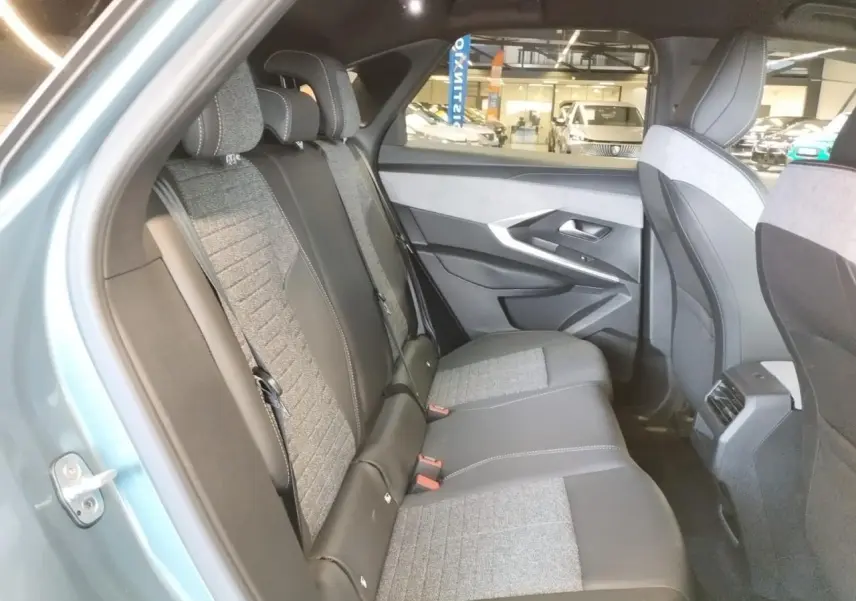Vue intérieure côté gauche des sièges arrière en tissu gris et cuir noir du Peugeot 3008 Bleu Azul 2025 hybride.