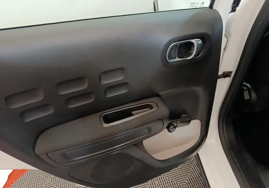 Vue rapprochée de la porte arrière droite noire et blanche de la Citroën C3 2020 avec poignée manuelle de vitre.