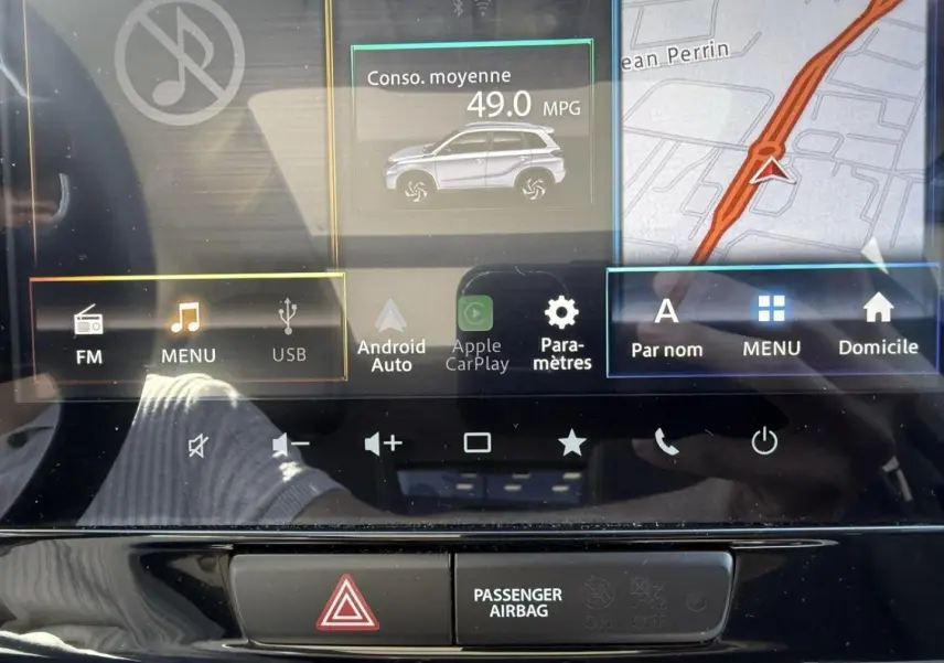 Image du tableau de bord du Suzuki Vitara 2025, écran tactile central affichant la consommation moyenne et la navigation.