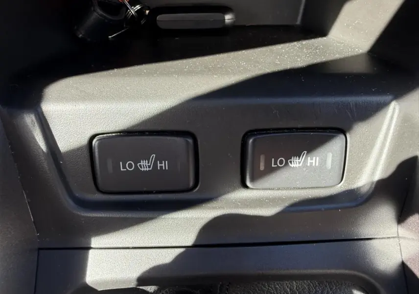 Gros plan sur les commandes des sièges chauffants avec réglages LO et HI dans un Suzuki Vitara bleu foncé 2025.