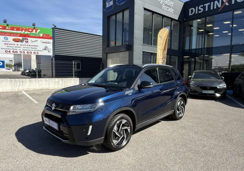 Suzuki Vitara 2025 bleu foncé métal en 3/4 avant droit, avec jantes alliage et détails noirs contrastants.
