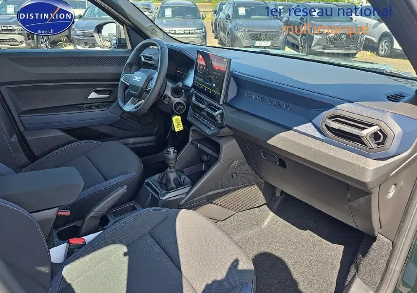 Intérieur noir du Dacia Duster 2025 vu côté conducteur, tableau de bord moderne avec écran tactile et volant multifonction.