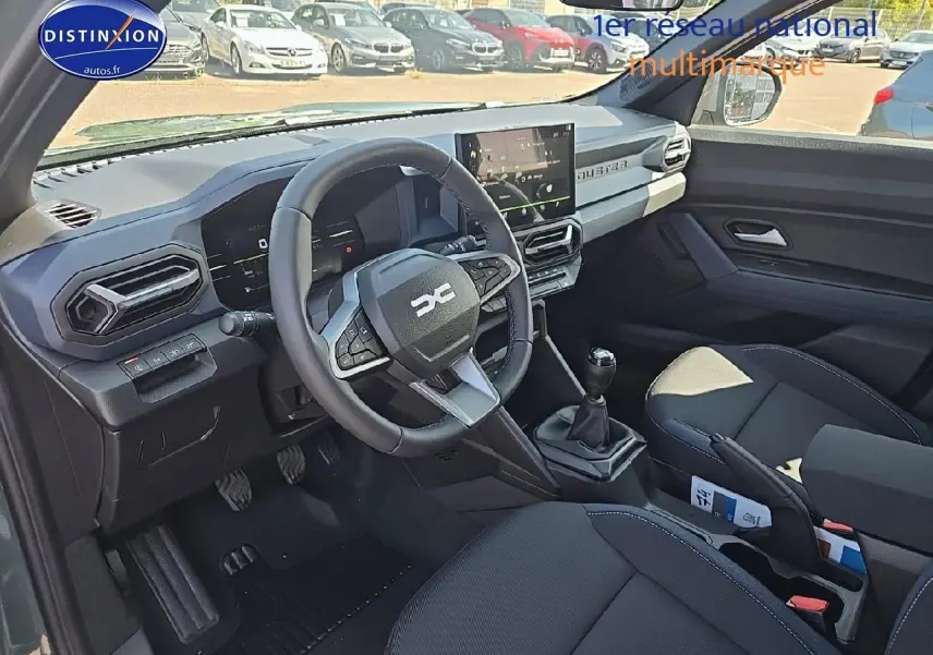 Intérieur avant du Dacia Duster 2025 vert kaki, vue côté conducteur avec volant multifonction et écran tactile.