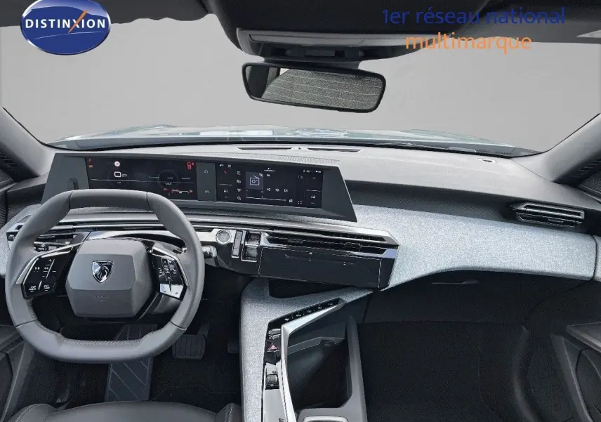 Intérieur du Peugeot 3008 Hybrid 2025 vu de face, tableau de bord moderne avec écran large et volant compact gris.