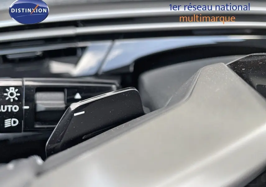 Gros plan sur la palette de changement de vitesses noire à l'intérieur d'un Peugeot 3008 Hybrid bleu Ingaro Metal.