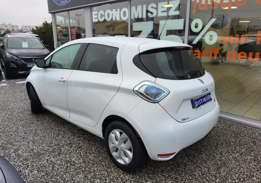 Vue 3/4 arrière droite d'une Renault ZOE blanche avec vitres arrière surteintées et feux arrière au design distinctif.