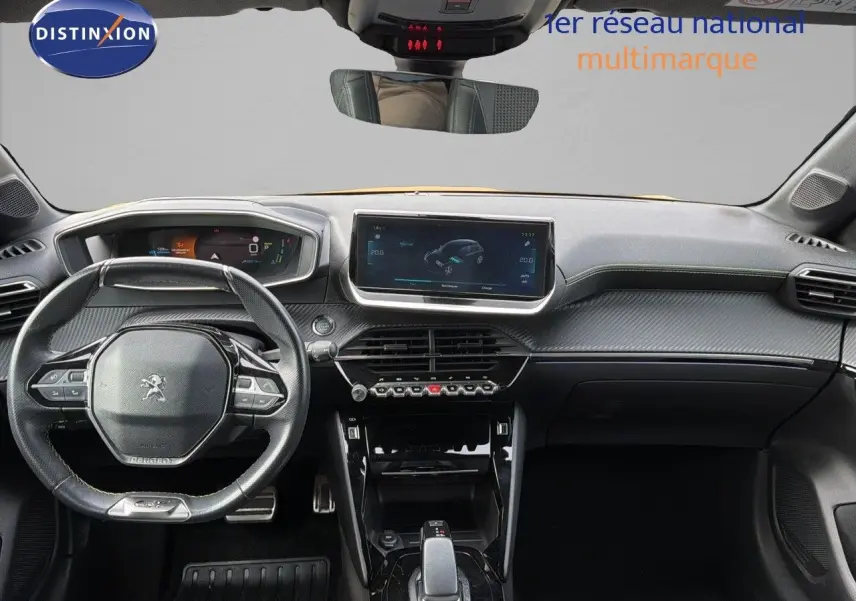 Vue intérieure frontale du tableau de bord et volant Peugeot 208 électrique GT Line avec finition carbone et écran tactile central.