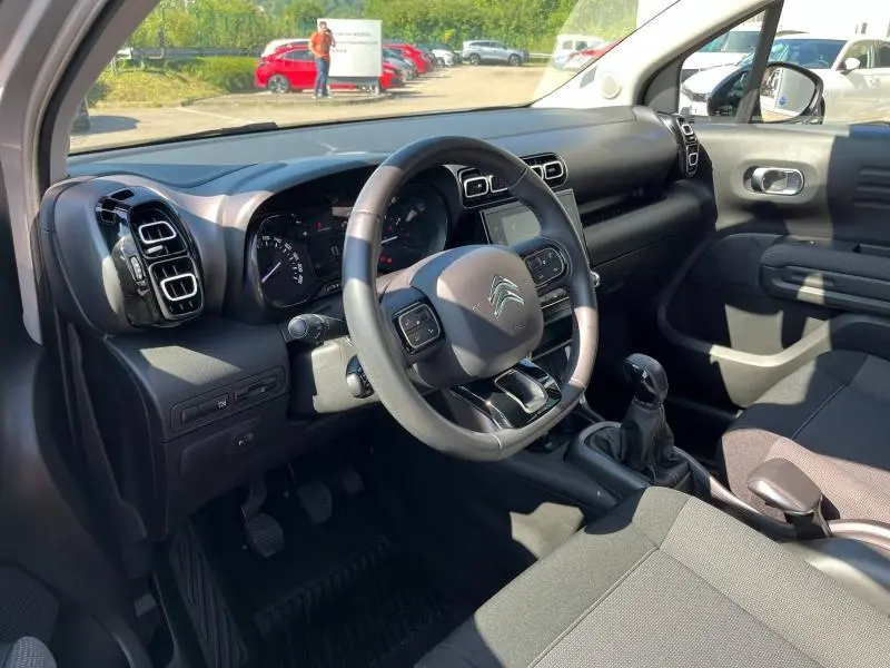 Intérieur côté conducteur de la Citroën C3 Aircross 2018, volant cuir et tableau de bord noir avec écran tactile.