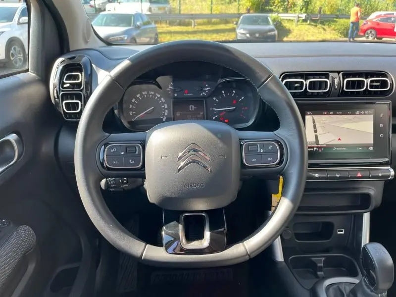 Vue frontale du volant cuir noir de la Citroën C3 Aircross 2018 avec tableau de bord et écran tactile GPS visible.