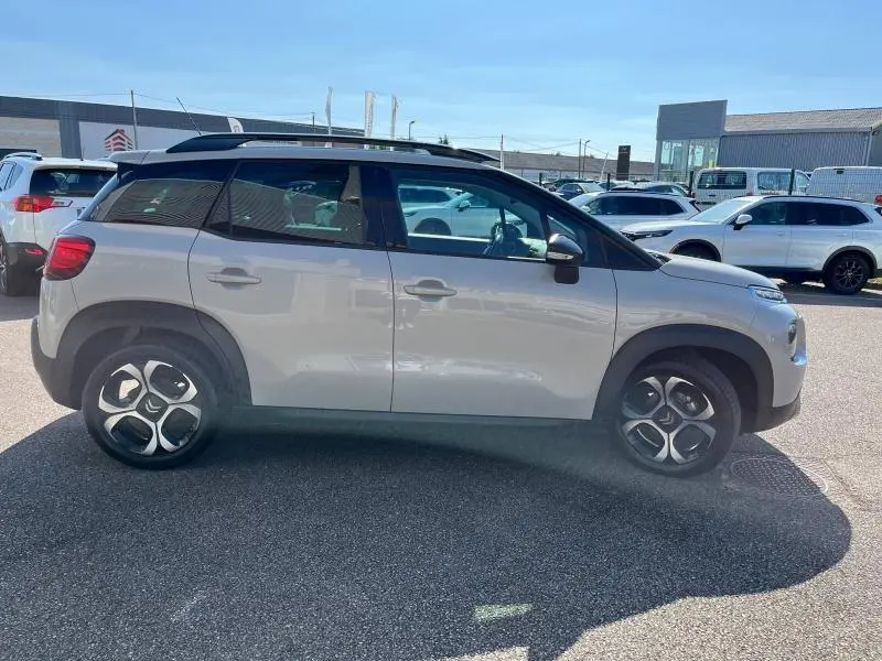 Profil côté gauche d'un Citroën C3 Aircross 2018 sable avec toit noir et jantes diamantées en extérieur.