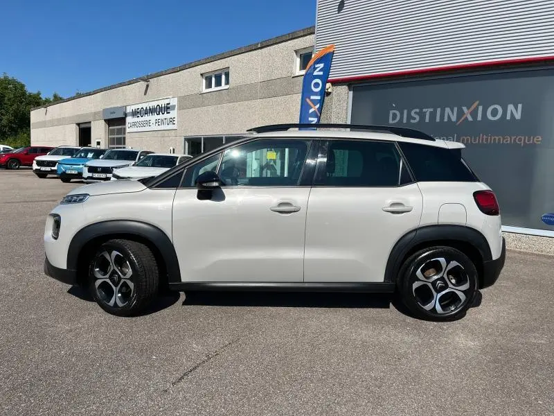 Profil côté gauche d'un Citroën C3 Aircross 2018 sable avec toit noir et jantes diamantées sur parking extérieur.