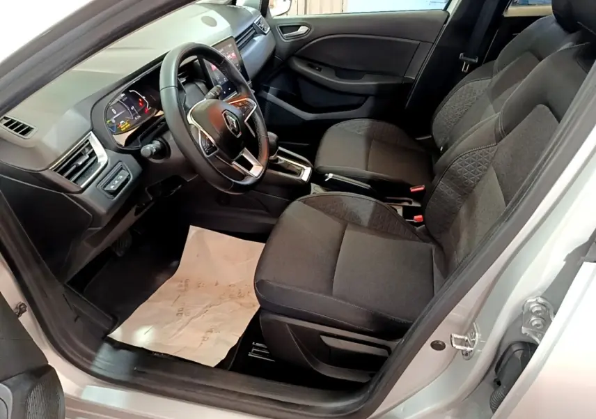 Vue intérieure côté conducteur de la Renault Clio Business E-TECH 140 2022, sièges noirs et volant multifonctions en cuir.