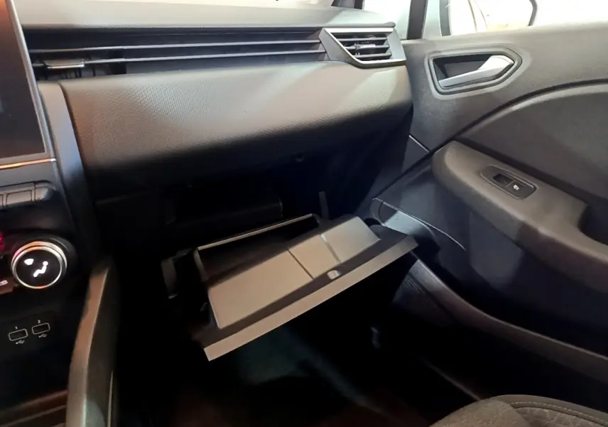 Intérieur de la Renault Clio Business E-TECH 2022, vue côté passager montrant la boîte à gants ouverte et tableau de bord gris foncé.