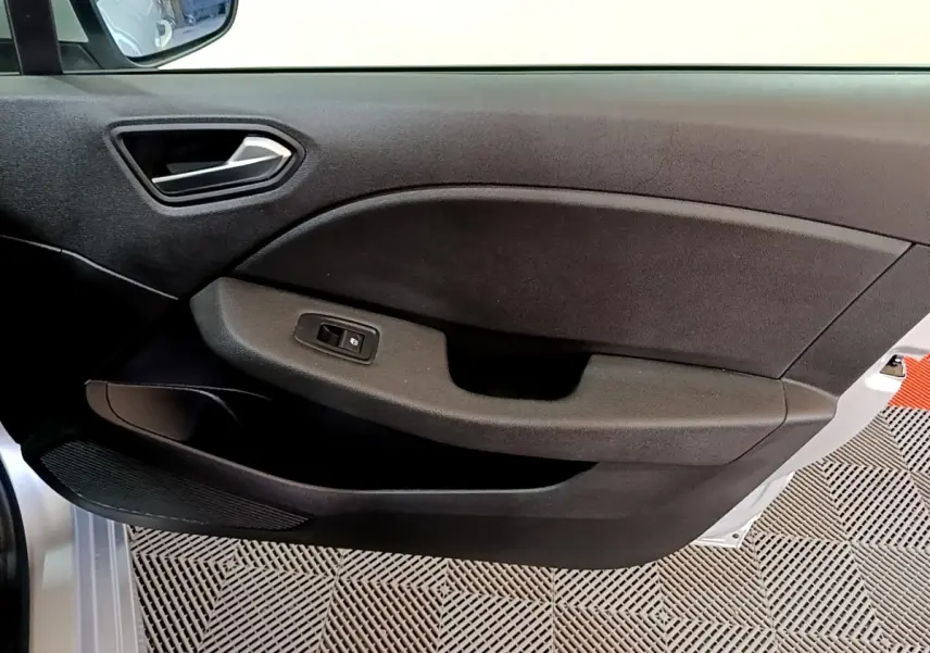 Vue intérieure côté gauche de la porte avant d'une Renault Clio Business E-TECH 140 gris foncé avec poignée et commande de vitre électrique.