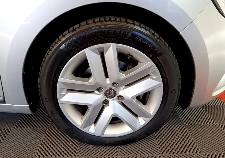 Vue rapprochée sur la roue avant droite d'une Renault Clio Business E-TECH 140 gris foncé, avec passage de roue visible.