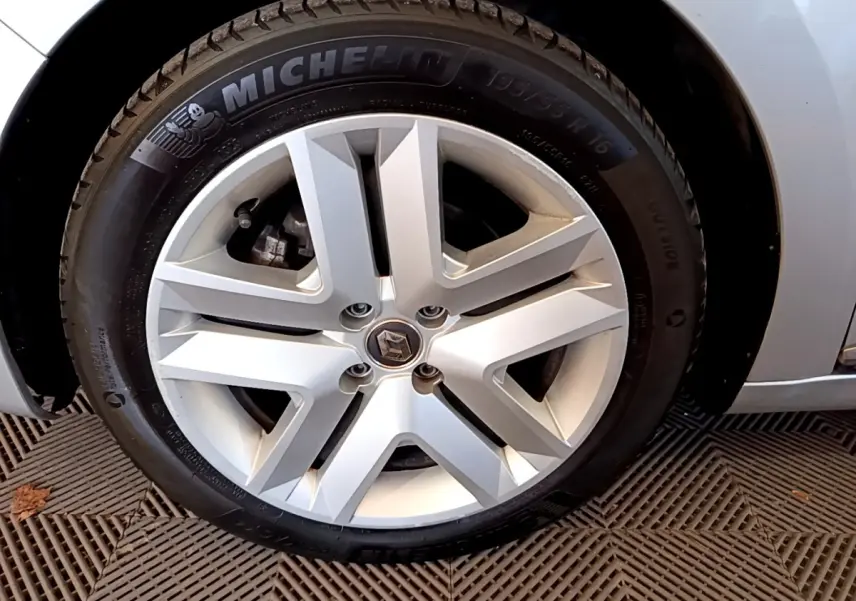 Gros plan sur la roue avant droite d'une Renault Clio gris foncé, avec pneu Michelin visible.
