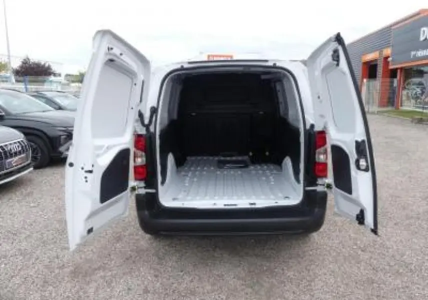 Vue arrière du Peugeot Partner XL blanc 2025 avec portes battantes ouvertes et espace de chargement vide.