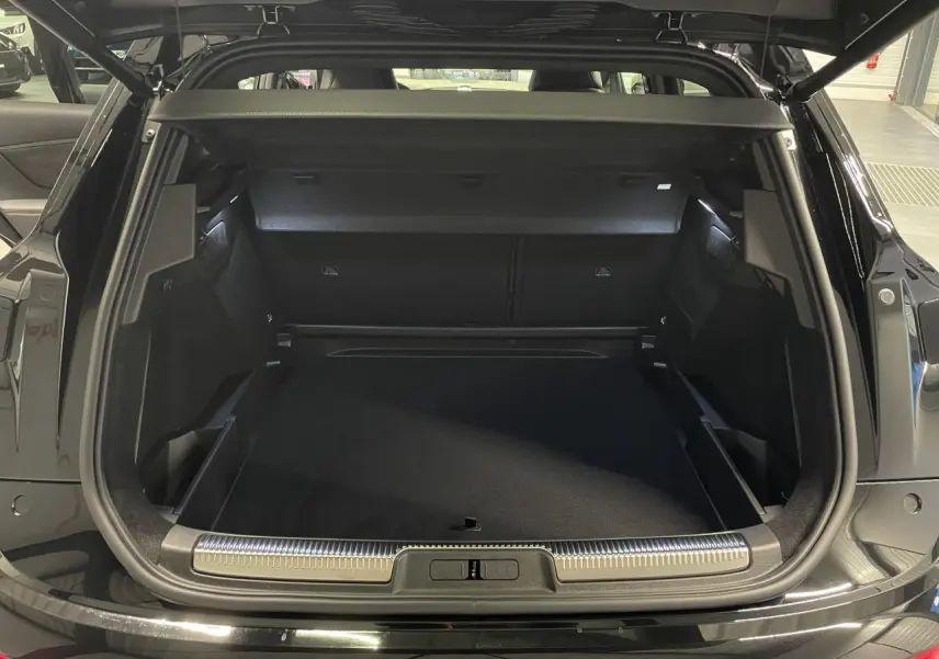 Coffre ouvert vu de l'arrière d'un DS7 Crossback noir métallisé avec seuil de coffre chromé et intérieur spacieux.