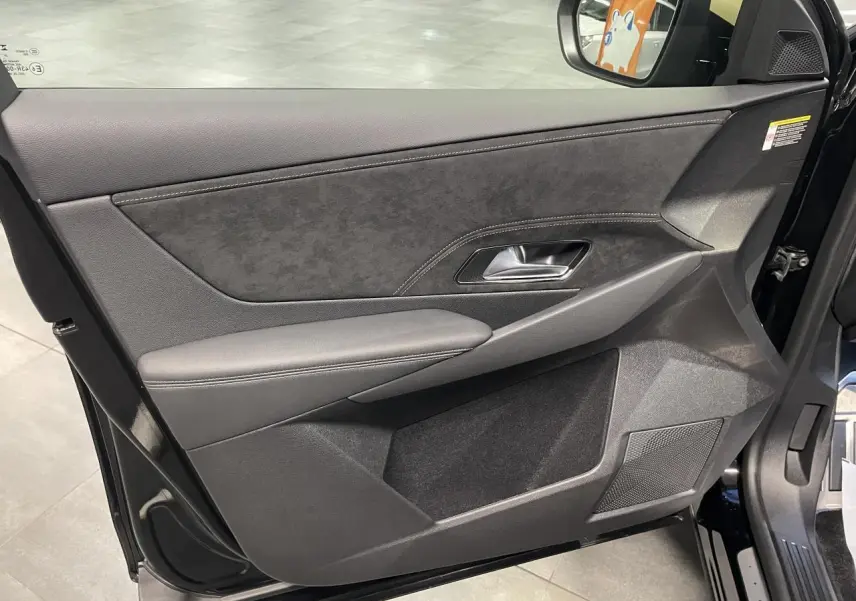 Vue intérieure côté gauche de la porte avant d’un DS7 Crossback noir métallisé avec garniture Alcantara et surpiqûres.