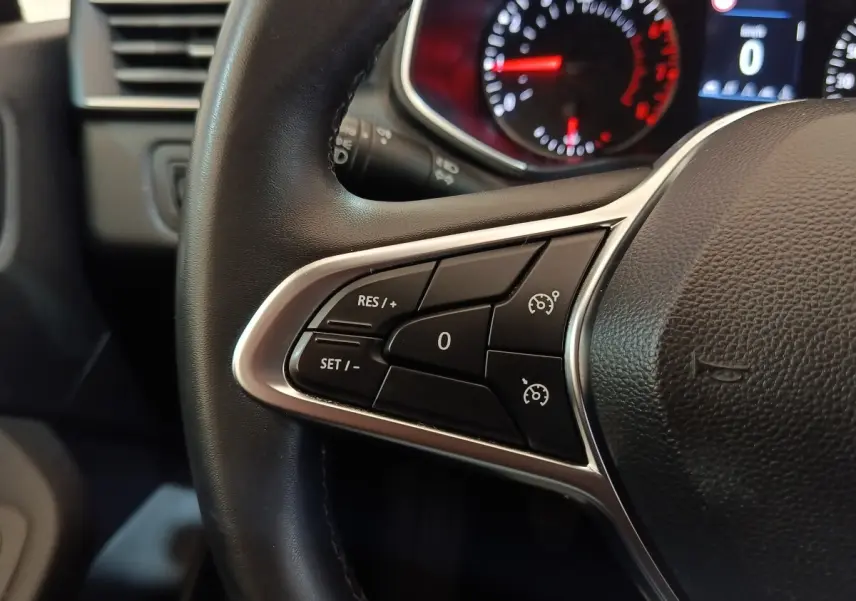 Gros plan sur le volant cuir synthétique noir de la Renault Clio Business 2021, avec commandes multifonctions côté gauche.