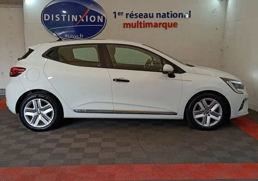 Profil côté gauche d'une Renault Clio Business blanche de 2021, avec jantes alliage et logo Clio sur la porte arrière.