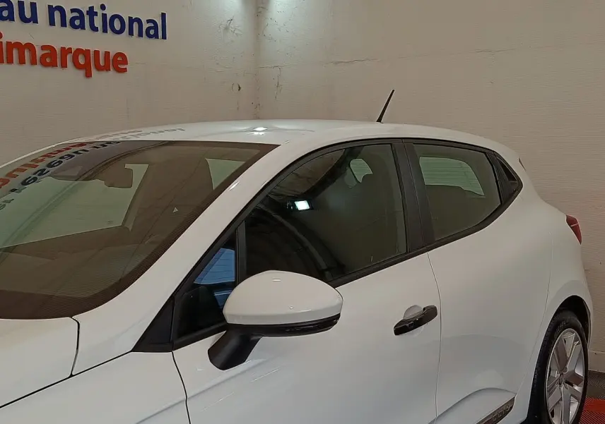 Profil côté gauche de la Renault Clio Business blanche 2021, avec rétroviseur et poignées noires contrastantes.