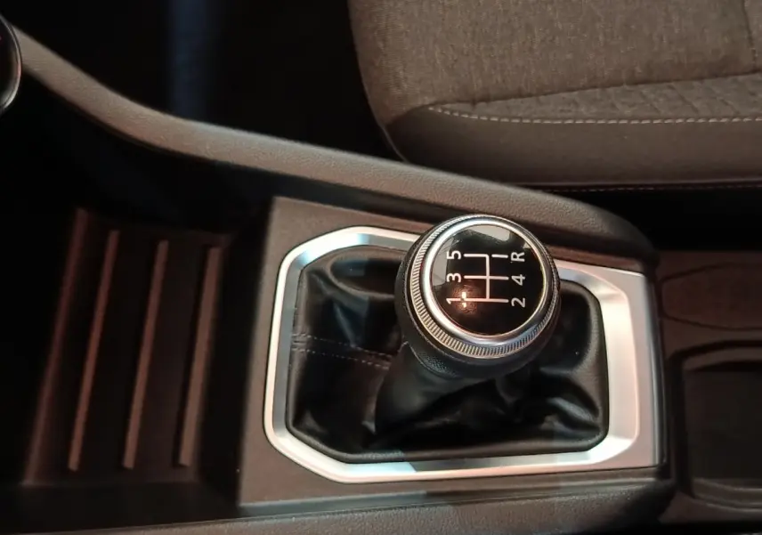 Le levier de vitesse manuel noir avec surpiqûres blanches de la Renault Clio Business SCe 65 vue en gros plan.