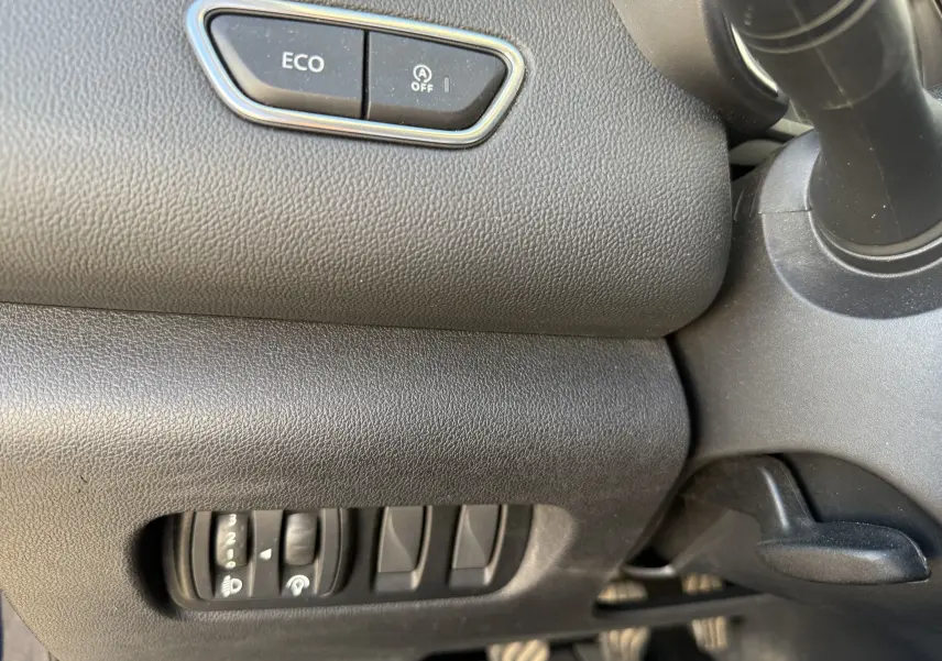 Détail intérieur côté gauche du tableau de bord du Renault Kadjar 1.5 DCI bleu, avec bouton ECO et commandes d’éclairage.