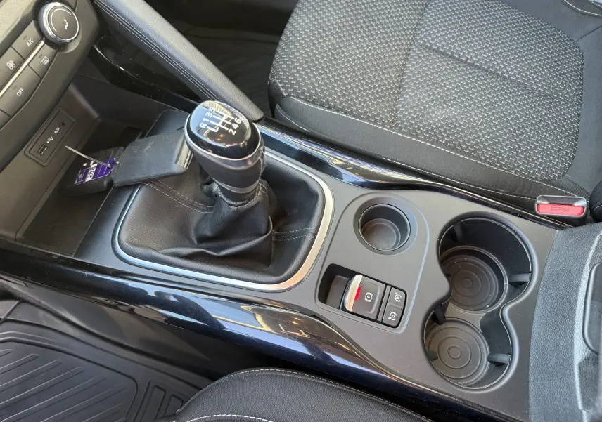 Vue intérieure rapprochée de la console centrale du Renault Kadjar 2019, avec levier de vitesse manuel et sièges tissu gris.