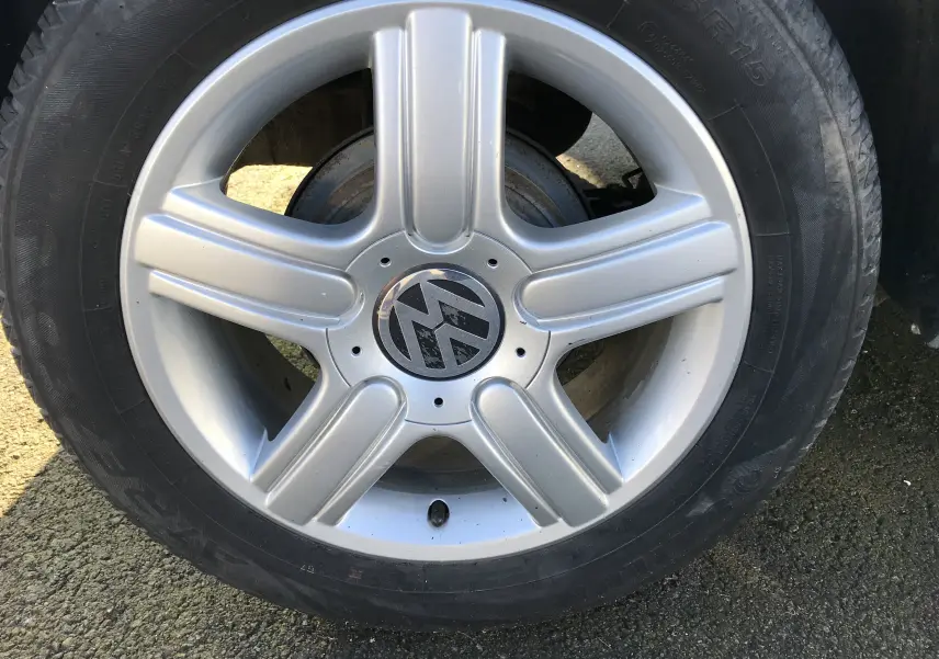 Gros plan sur la jante alliage argentée à 5 branches d'une Volkswagen Polo Match gris argent de 2004.