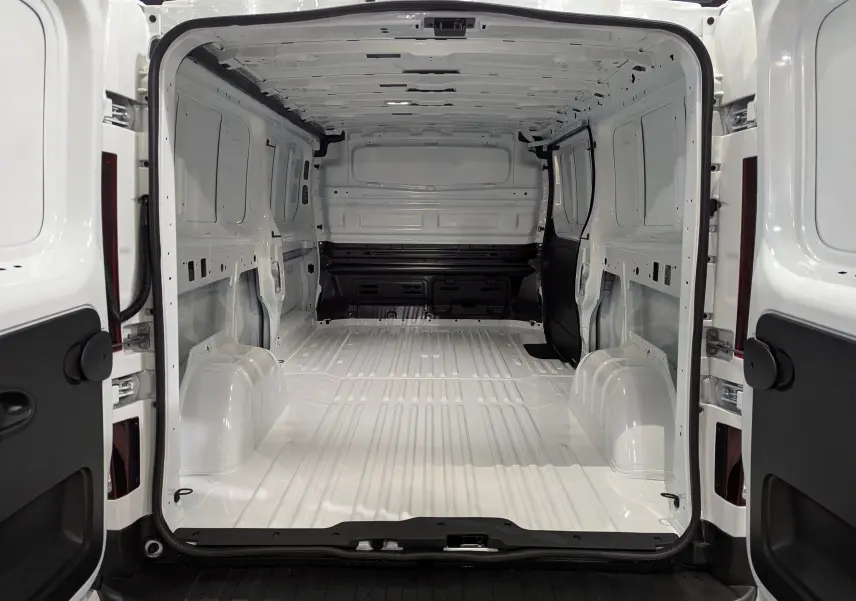 Vue arrière ouverte du Renault Trafic Fourgon blanc minéral L2H1 2025, montrant l'intérieur vide et spacieux de la zone de chargement.