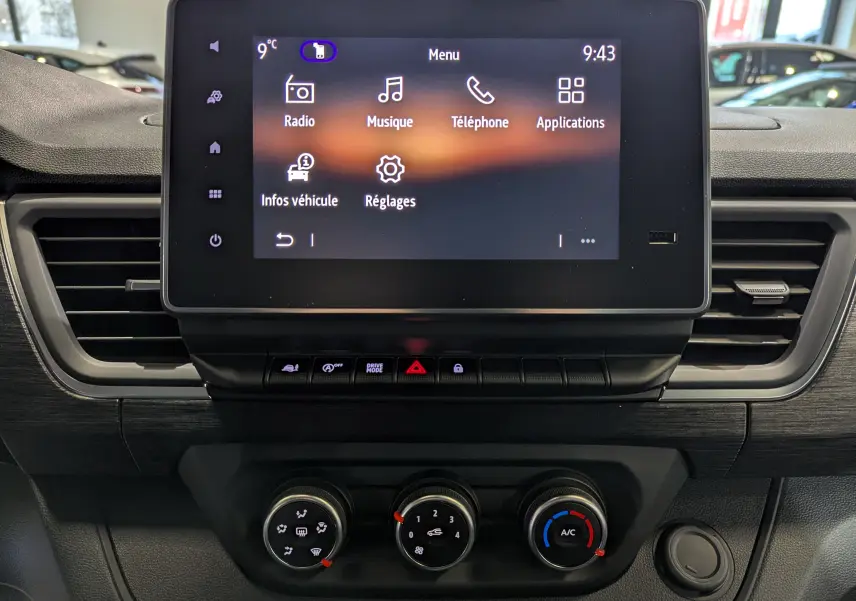 Vue rapprochée du tableau de bord du Renault Trafic Fourgon 2025 avec écran tactile et commandes de climatisation.