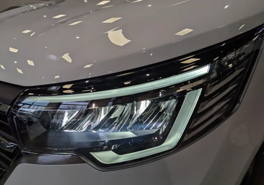 Gros plan sur le phare avant droit blanc minéral du Renault Trafic Fourgon L2H1 2025 avec éclairage LED distinctif.