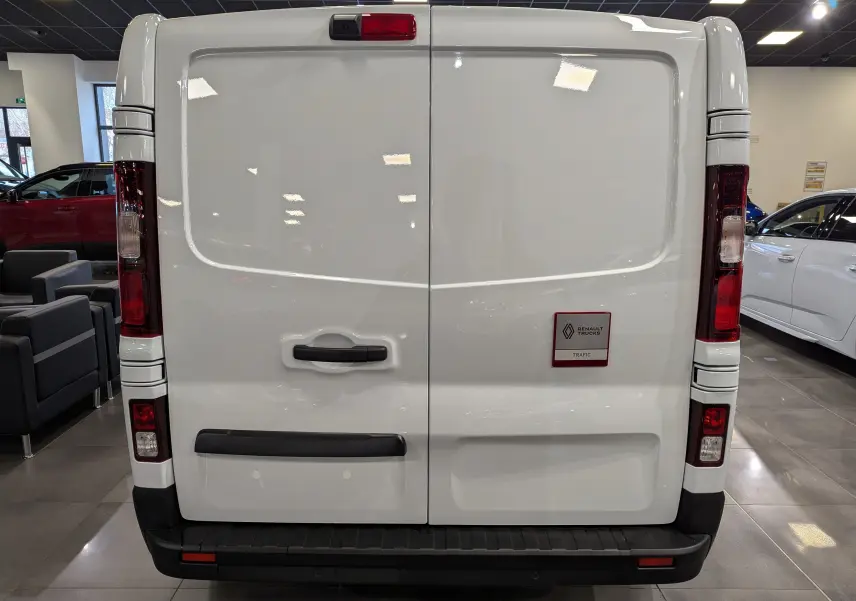 Vue arrière du Renault Trafic Fourgon blanc minéral 2025 avec portes battantes et feux verticaux rouges.